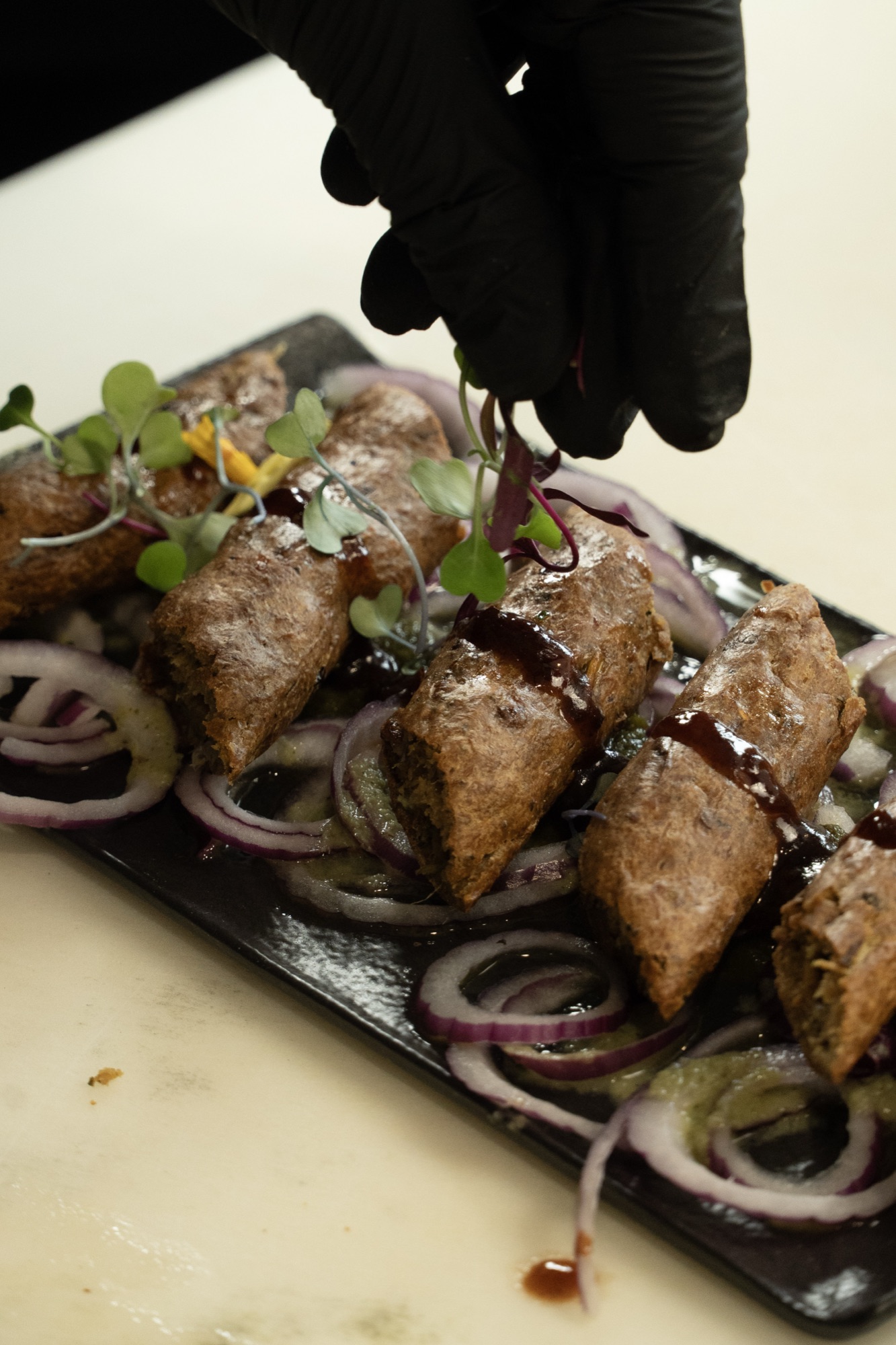 Sliced frankie rolls over red onion with tamarind drizzle